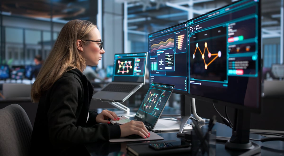 Woman Works On Laptop Monitoring Real-time Network Security Threats